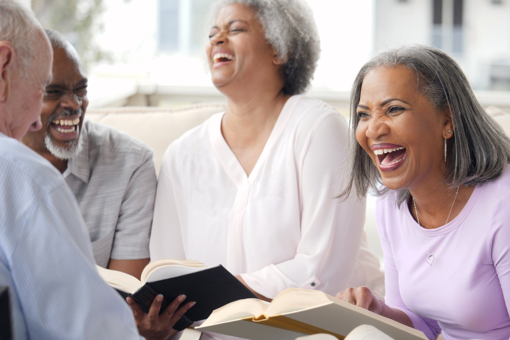 Group of older adults gathered around a table at a hearing loss-friendly club meeting