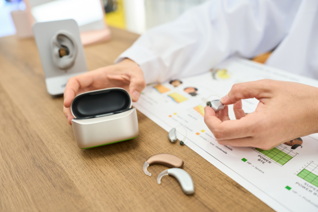Hearing care professional comparing hearing aid models, one type of communication device for hearing loss