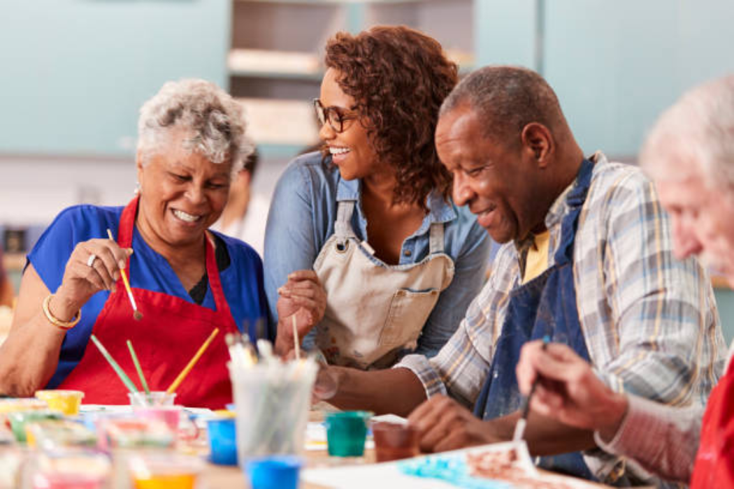 Older adults painting together at a community art class while trying a new hobby this fall